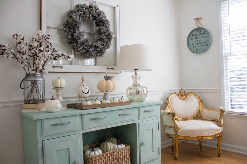 How to DIY a Neutral Farmhouse Decor for Fall - using paint from Amy Howard at Home, I transformed this sideboard into something rustic and gorgeous! The pumpkins, old window, and other various accents add a pop of fun to our living room while still keeping it soothing.